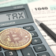 Stock image of bitcoin and tax forms